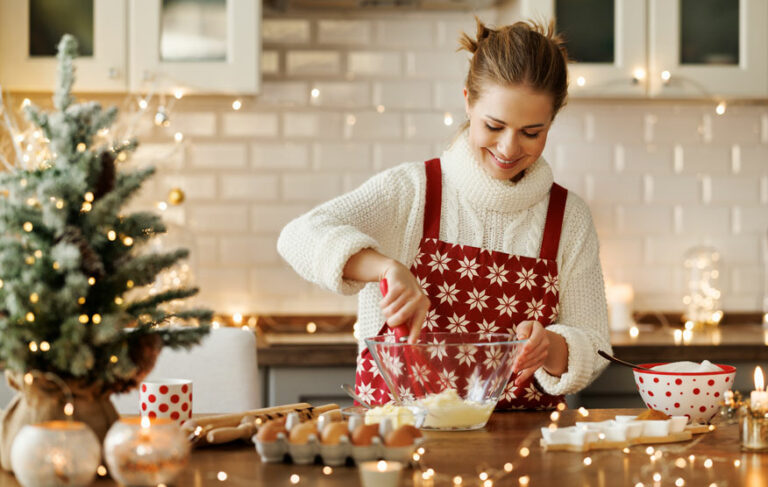 Schöne Frau beim Backen in einer Weihnachtlich geschmückten Küche